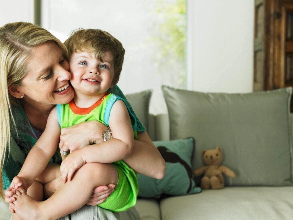 Woman holding a smiling toddler.